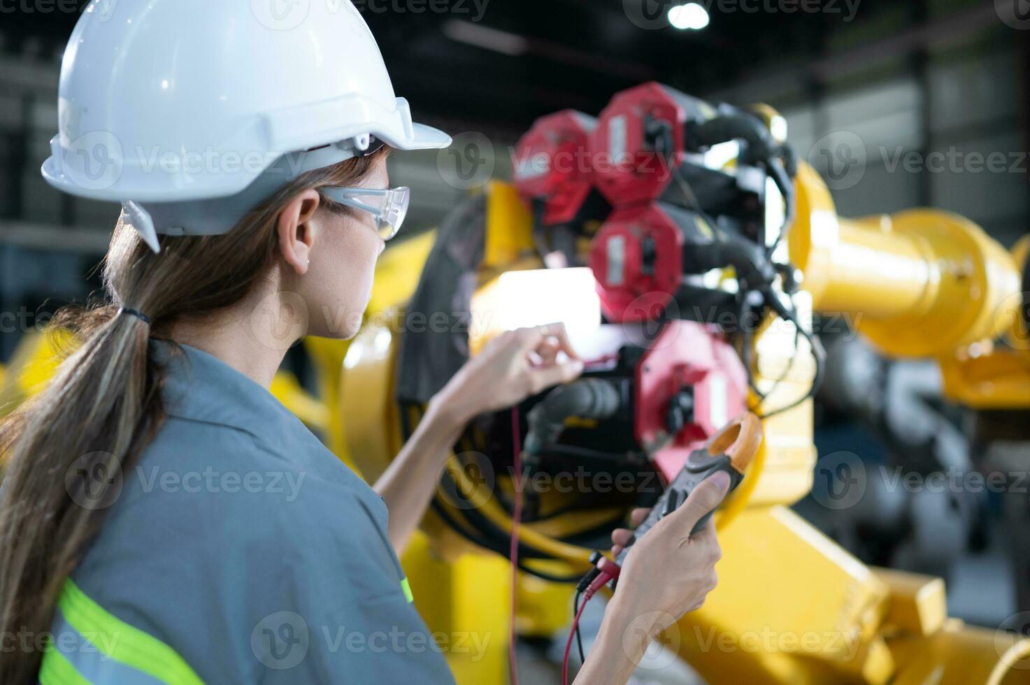 In the robots warehouse, A female engineer inspects the electrical system of every robotics arm, before delivering to the customer. photo