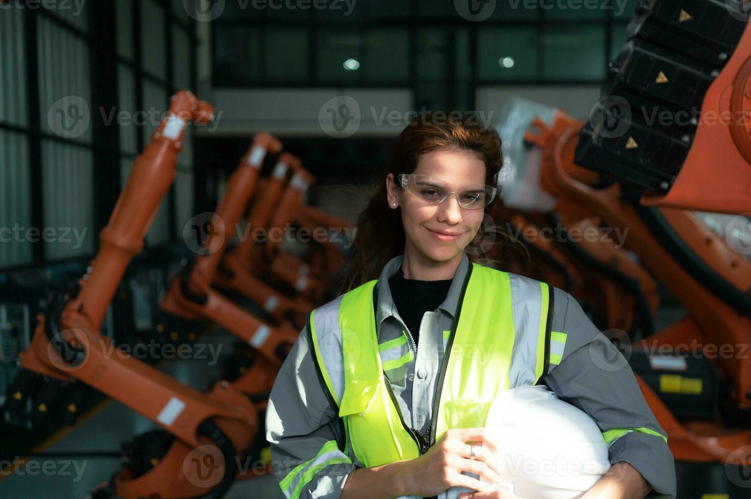 Portrait of female engineer with the mission of auditing, testing, improving software and calibrating robotics arm. photo