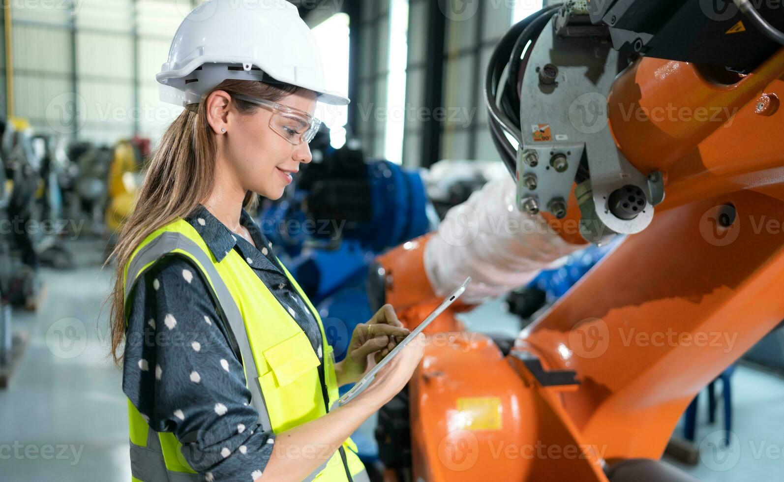 un hembra ingeniero instala un programa en un robótica brazo en un robot depósito. y prueba el operación antes de enviando el máquina a el cliente. foto