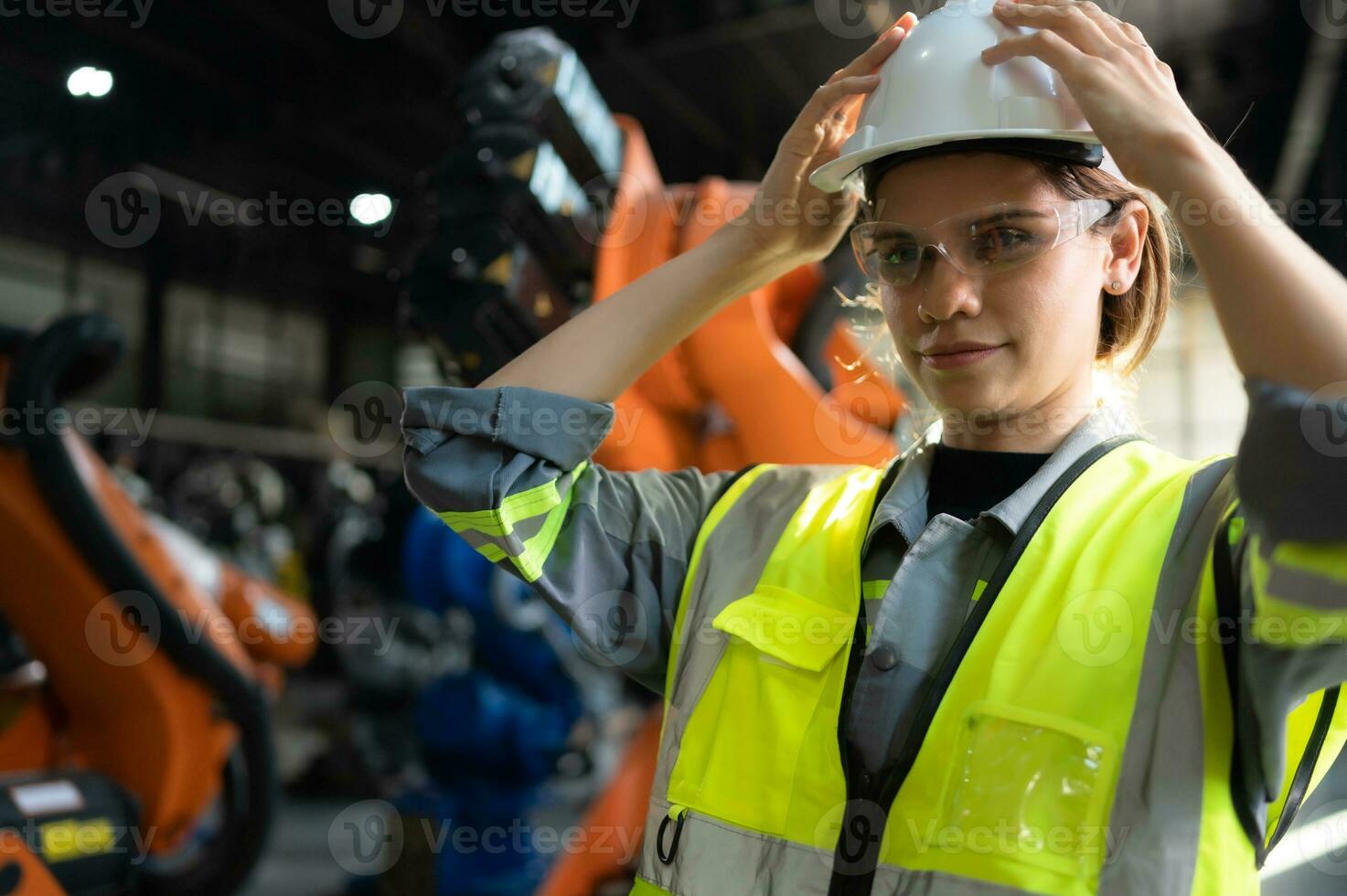Portrait of female engineer with the mission of auditing, testing, improving software and calibrating robotics arm. photo