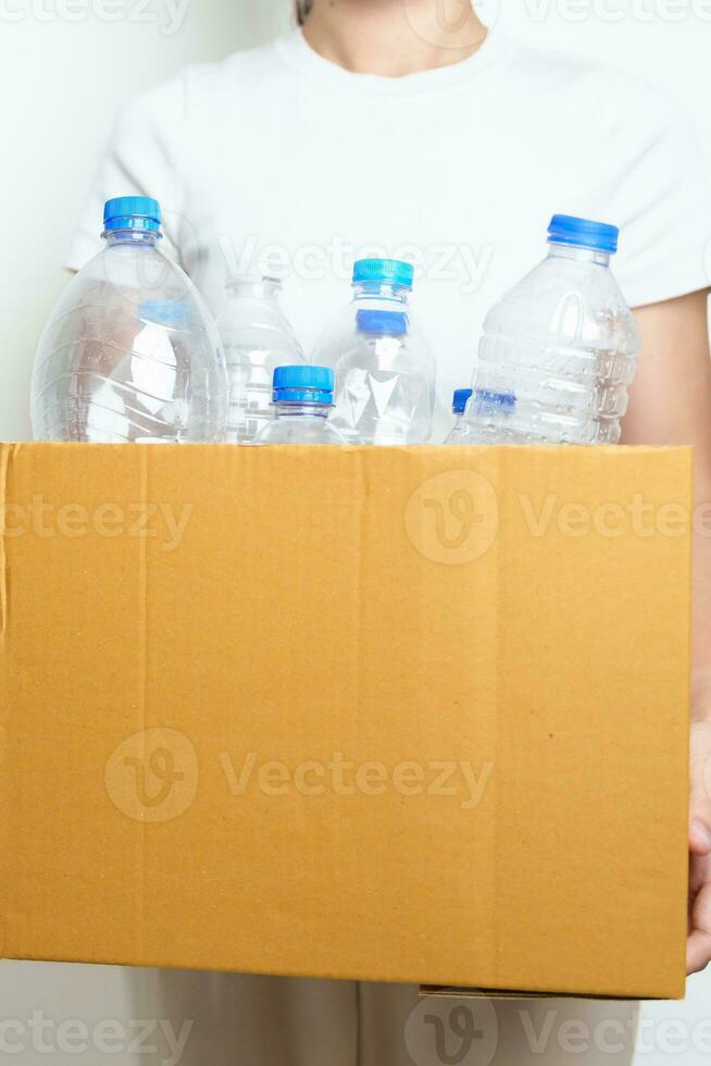 Volunteer keep plastic bottle into paper box at home or office. Hand Sorting Recycle garbage. Ecology, Environmental, pollution, Dispose recycling, waste management and trash Separation concept photo
