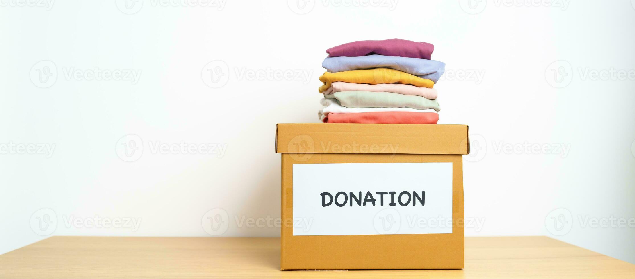 Donation, Charity, Volunteer, Giving and Delivery Concept. Clothes with Donation box at home or office for support and help poor, refugee and homeless people. Copy space for text photo