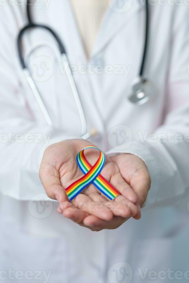 médico con lgbtq arco iris cinta para apoyo lesbiana, homosexual, bisexual, Transgénero y queer comunidad y contento orgullo mes concepto foto