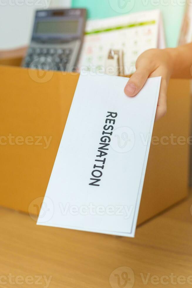 Resignation, Layoff, Unemployment, Dismiss, Job quit, Jobless and Farewell concept. Businesswoman holding letter of Resign contract with documents cardboard box at office photo