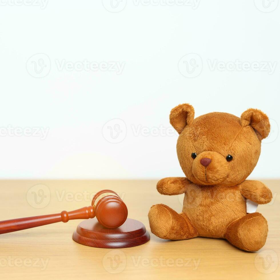 niños, niño y familia ley conceptos. juguete oso con mazo justicia martillo en escritorio en palacio de justicia. foto