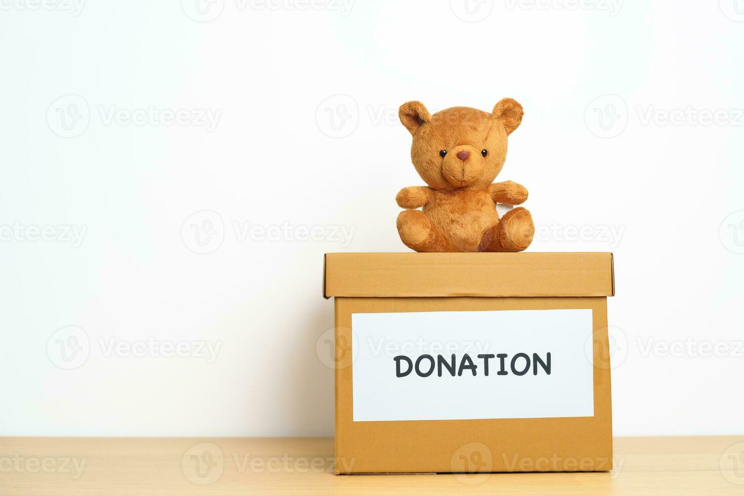 Kid Donation, Charity, Volunteer, Giving and Delivery Concept. Bear doll and Clothes with Donation box at home for support and help poor, refugee and homeless people. Copy space for text photo