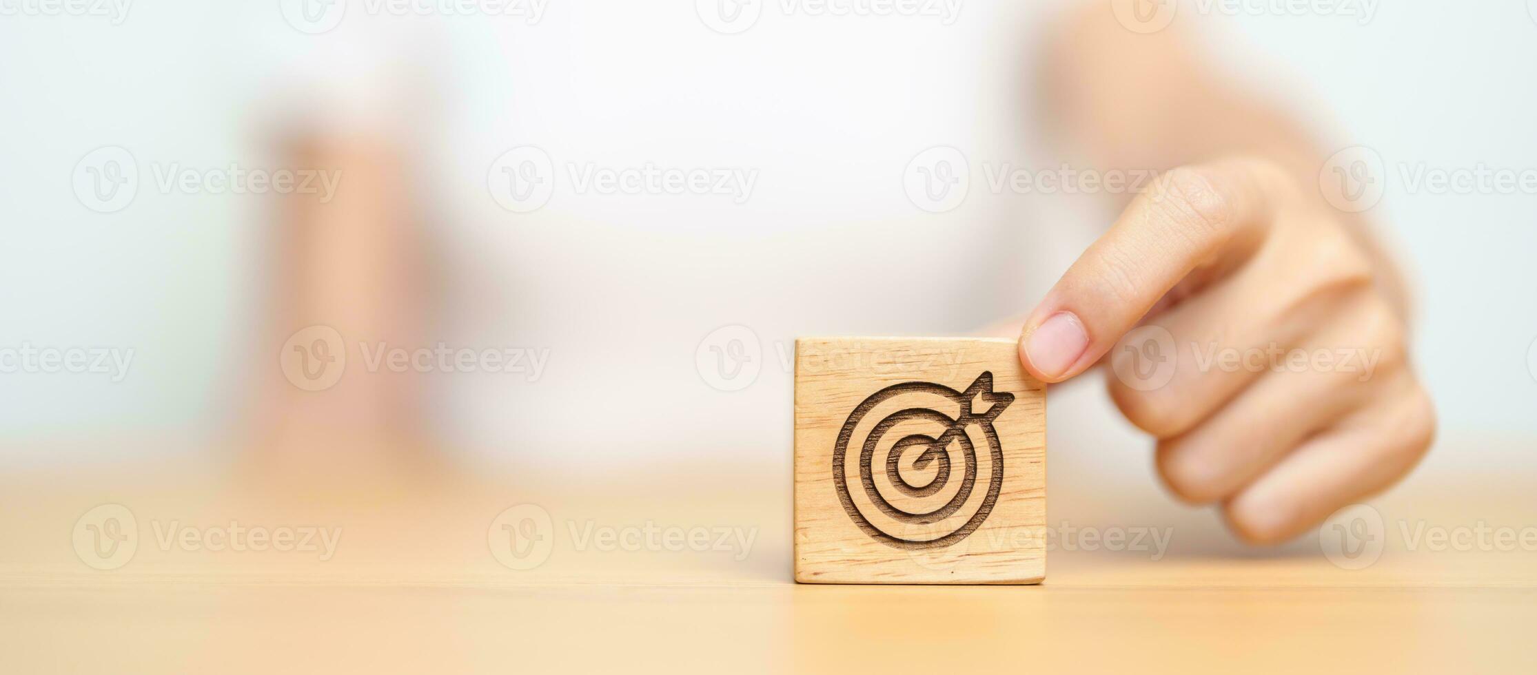 hand hold dartboard block with business goal, strategy, target, mission, action, objective, aim and success concept photo