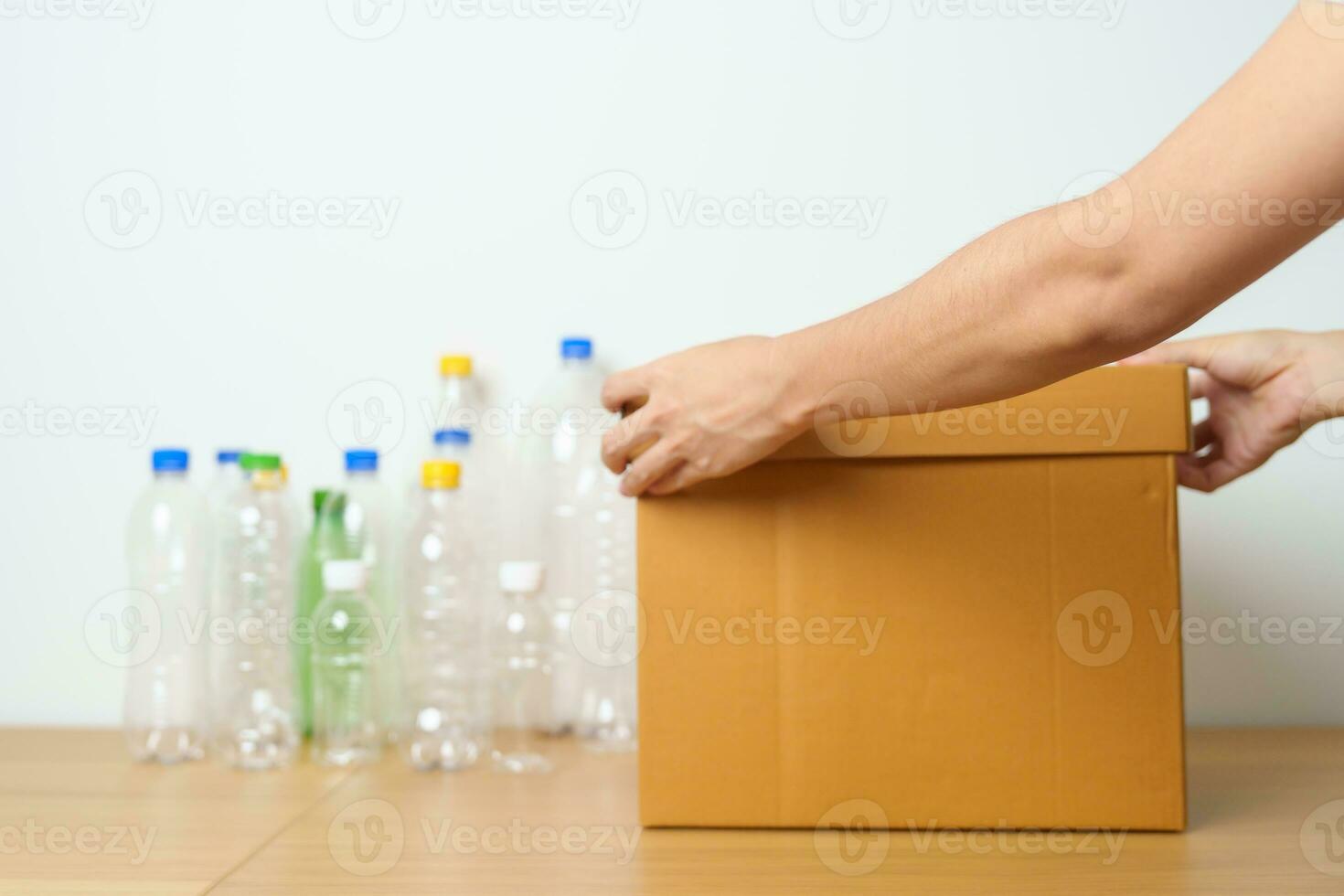 Volunteer keep plastic bottle into paper box at home or office. Hand Sorting Recycle garbage. Ecology, Environmental, pollution, Dispose recycling, waste management and trash Separation concept photo