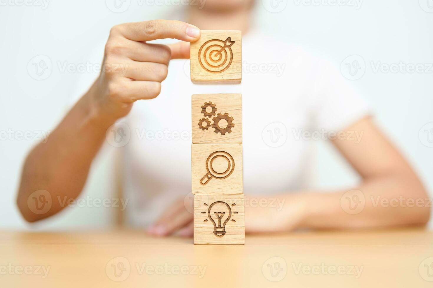 Woman hand holding dartboard above Gear, magnifying and Lightbulb icon block. business planning process, goal, strategy, target, mission, action, research, teamwork and idea concept photo