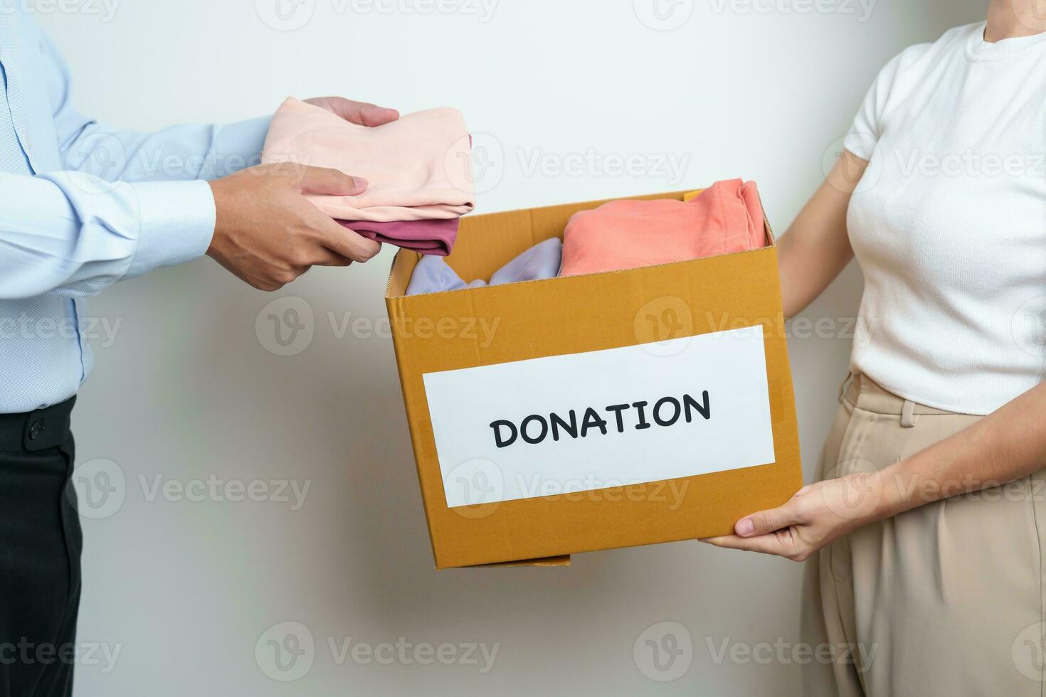 Donation, Charity, Volunteer, Giving and Delivery Concept. People donate Clothes into Donation box at home or office for support and help poor, refugee and homeless people. Copy space for text photo