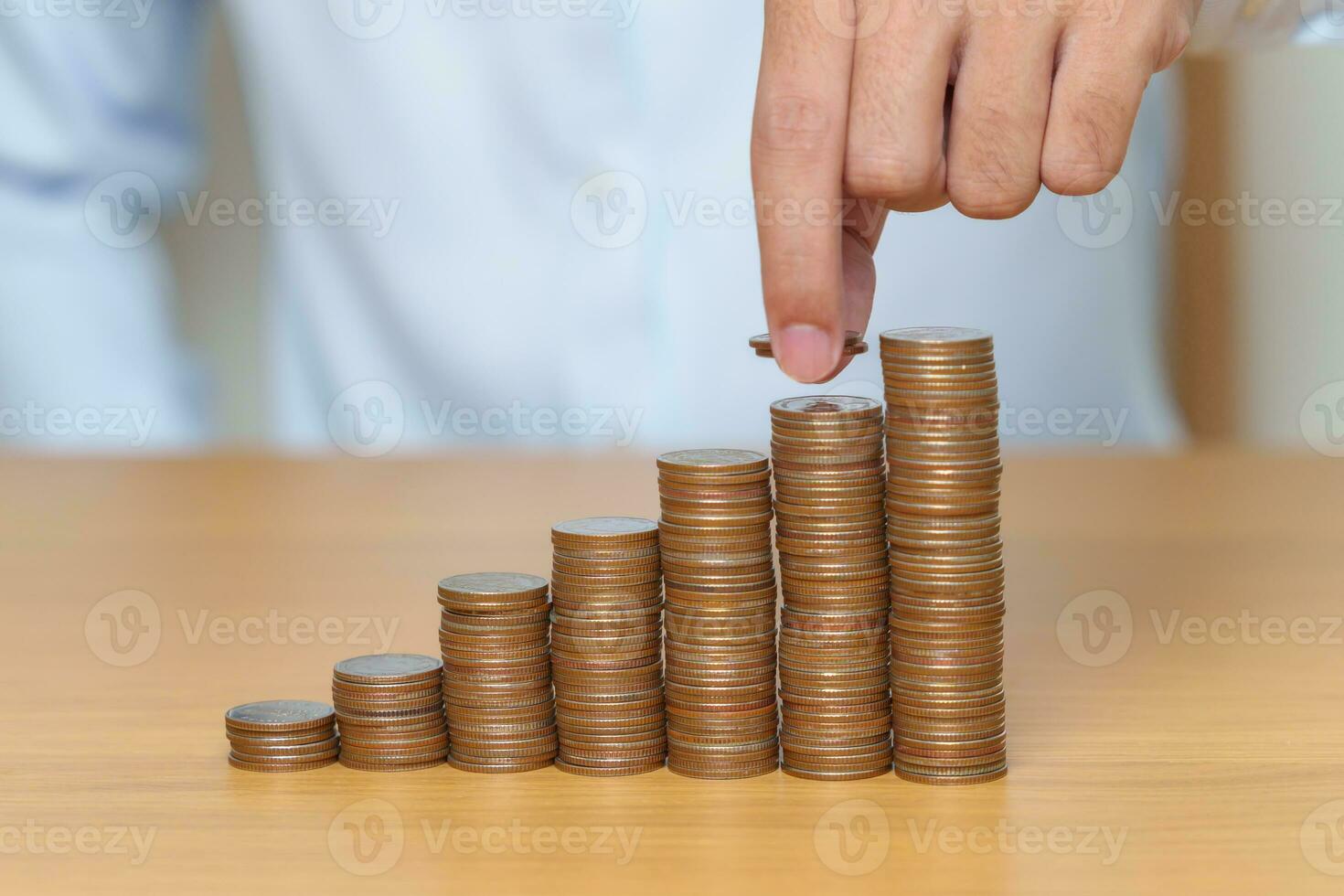 Money Saving for Future Plan, Retirement fund, Pension, Investment, Wealth Business and Financial concepts. hand putting coin into stack on table, Money counting and stack arrangement for deposit photo