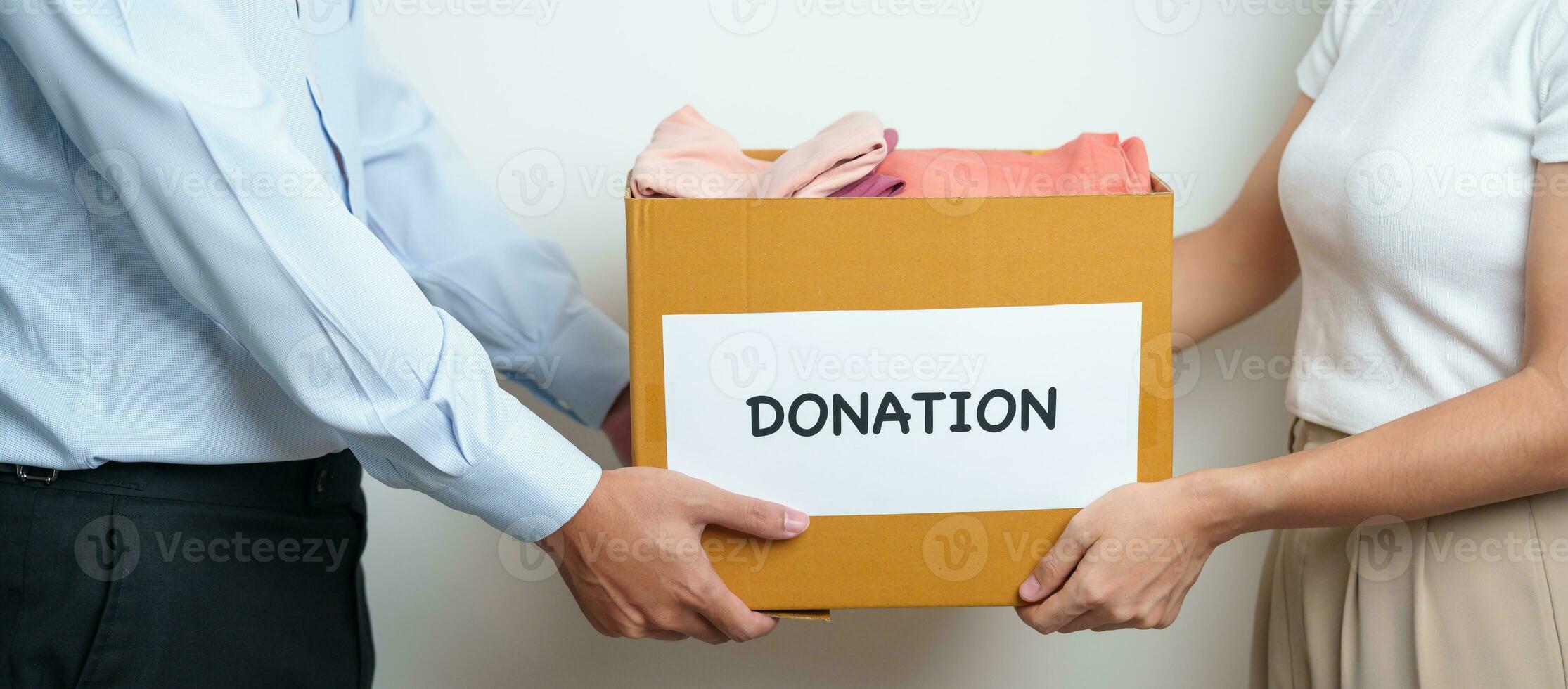 Donation, Charity, Volunteer, Giving and Delivery Concept. People donate Clothes into Donation box at home or office for support and help poor, refugee and homeless people. Copy space for text photo