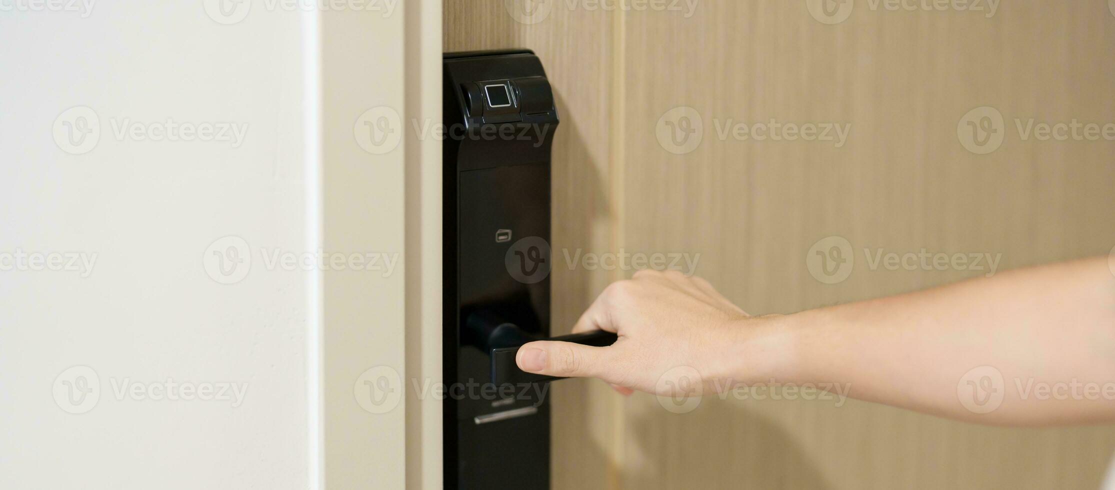 Hand using smart digital door lock while open or close the door at home or apartment. NFC Technology, Fingerprint scan, keycard, PIN number, smartphone, electrical and contactless lifestyle concepts photo