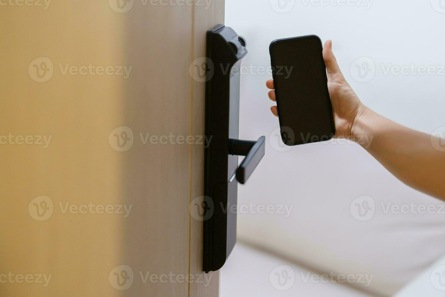 Hand using smartphone for open digital door lock at home or apartment. NFC Technology, Fingerprint scan, keycard, PIN number, smartphone, electrical and contactless lifestyle concepts photo