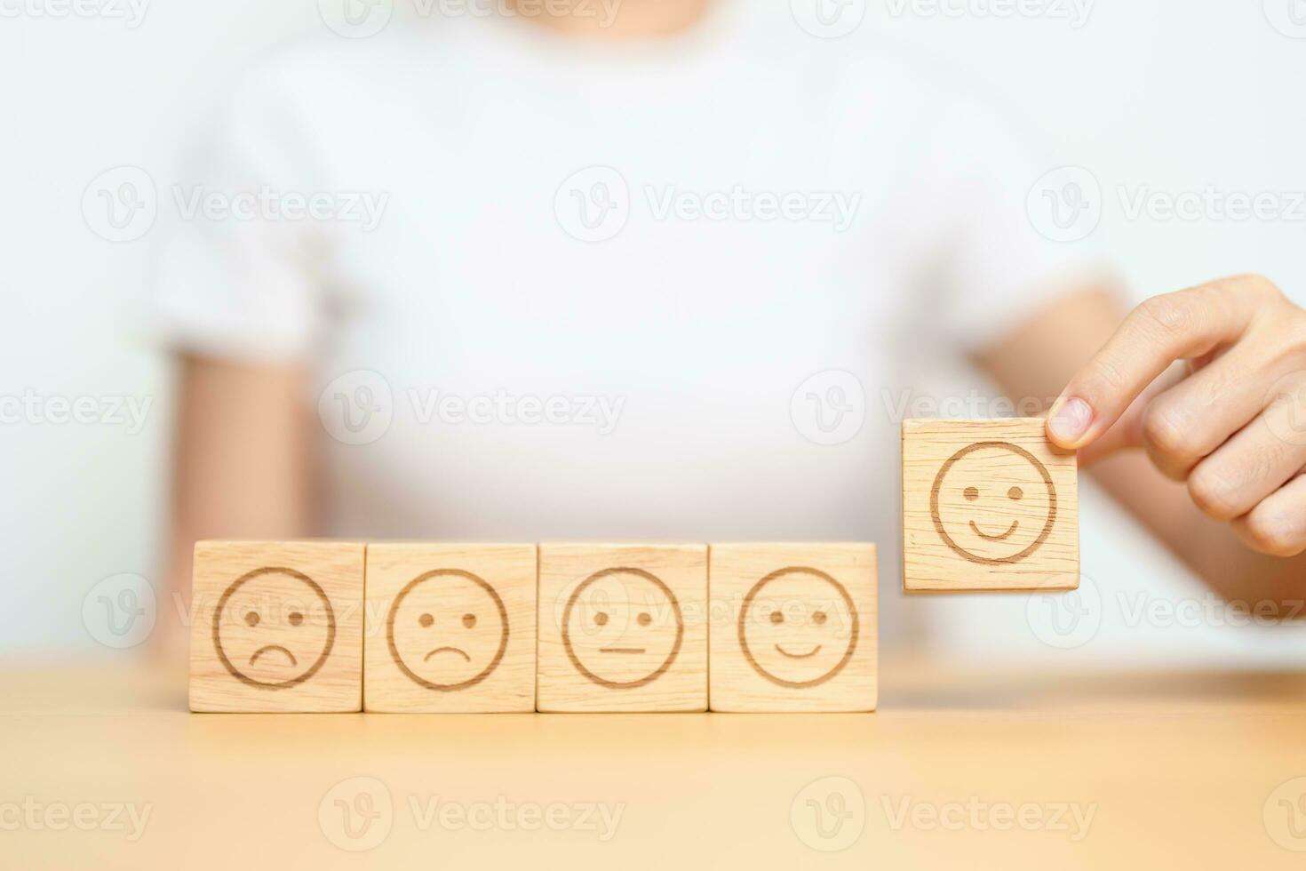 Hand choosing smile face from Emotion block for customer review, good experience, positive feedback, satisfaction, survey, evaluation, assessment, mood and world mental health day concept photo