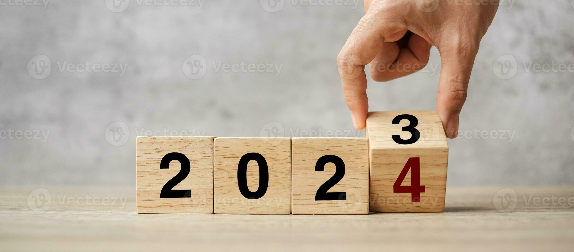 hand flipping block 2023 to 2024 text on table. Resolution, strategy, plan, goal, motivation, reboot, business and New Year holiday concepts photo