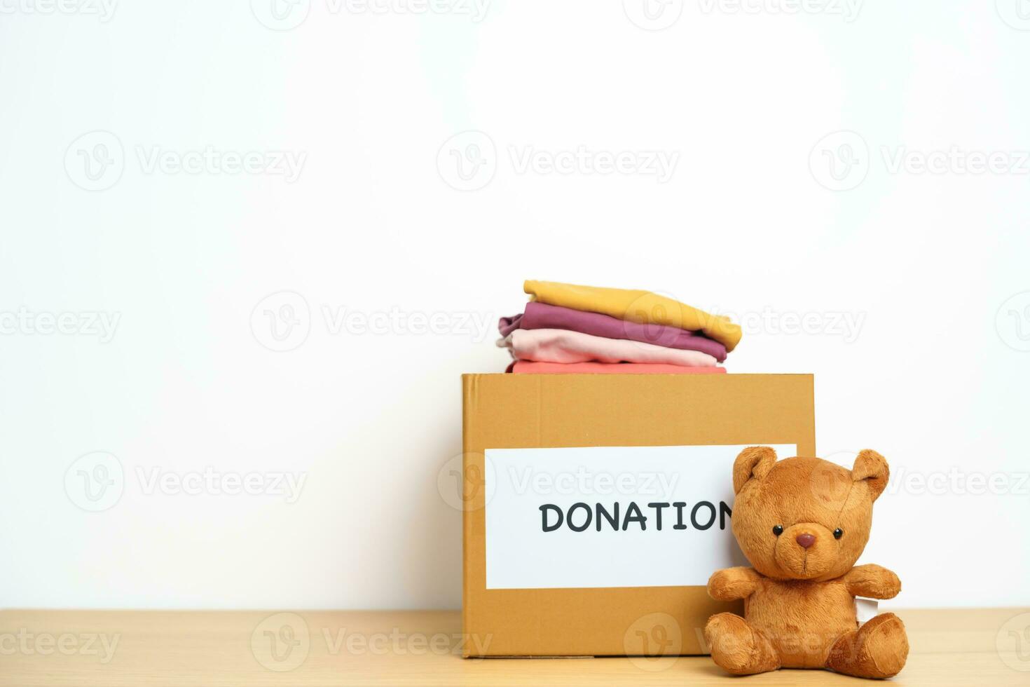 niño donación, caridad, voluntario, dando y entrega concepto. oso muñeca y ropa con donación caja a hogar para apoyo y ayuda pobre, refugiado y Vagabundo gente. Copiar espacio para texto foto
