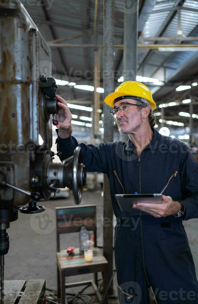 un mayor técnico usos un computadora a prueba el operación controlar de un acero puñetazos máquina. foto