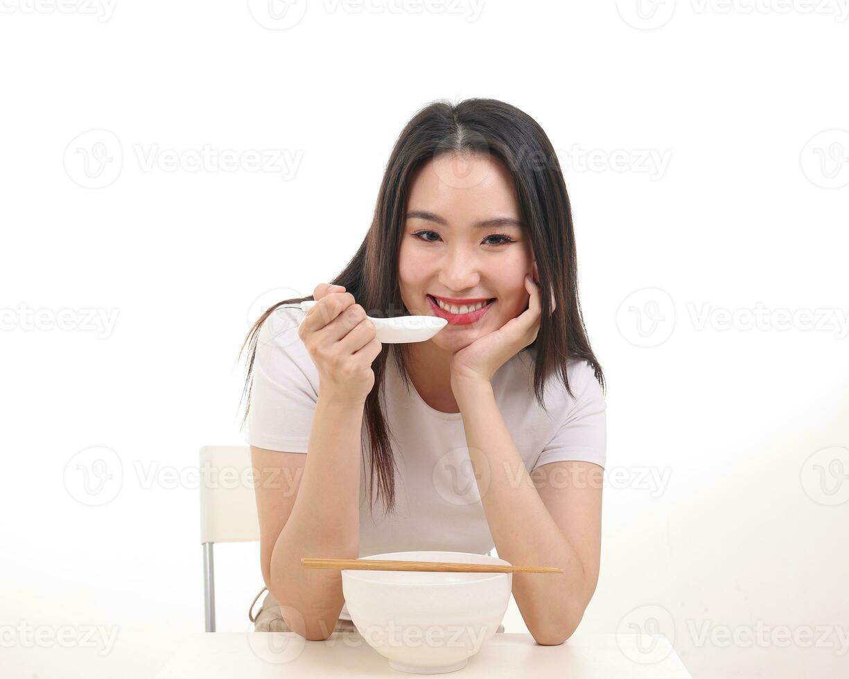Beautiful young south east Asian woman holding chinese empty chopstick soup spoon bowl utensil pretend acting posing see eat taste feed offer satisfaction yummy white background happy photo