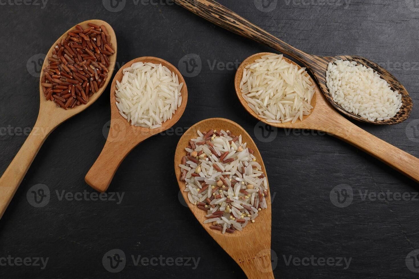 Long grain basmati medium grain jasmine short grain pilaf polau risotto brown low glycaemic index gi rice in wooden spoon on black background copy text space top flat lay view photo