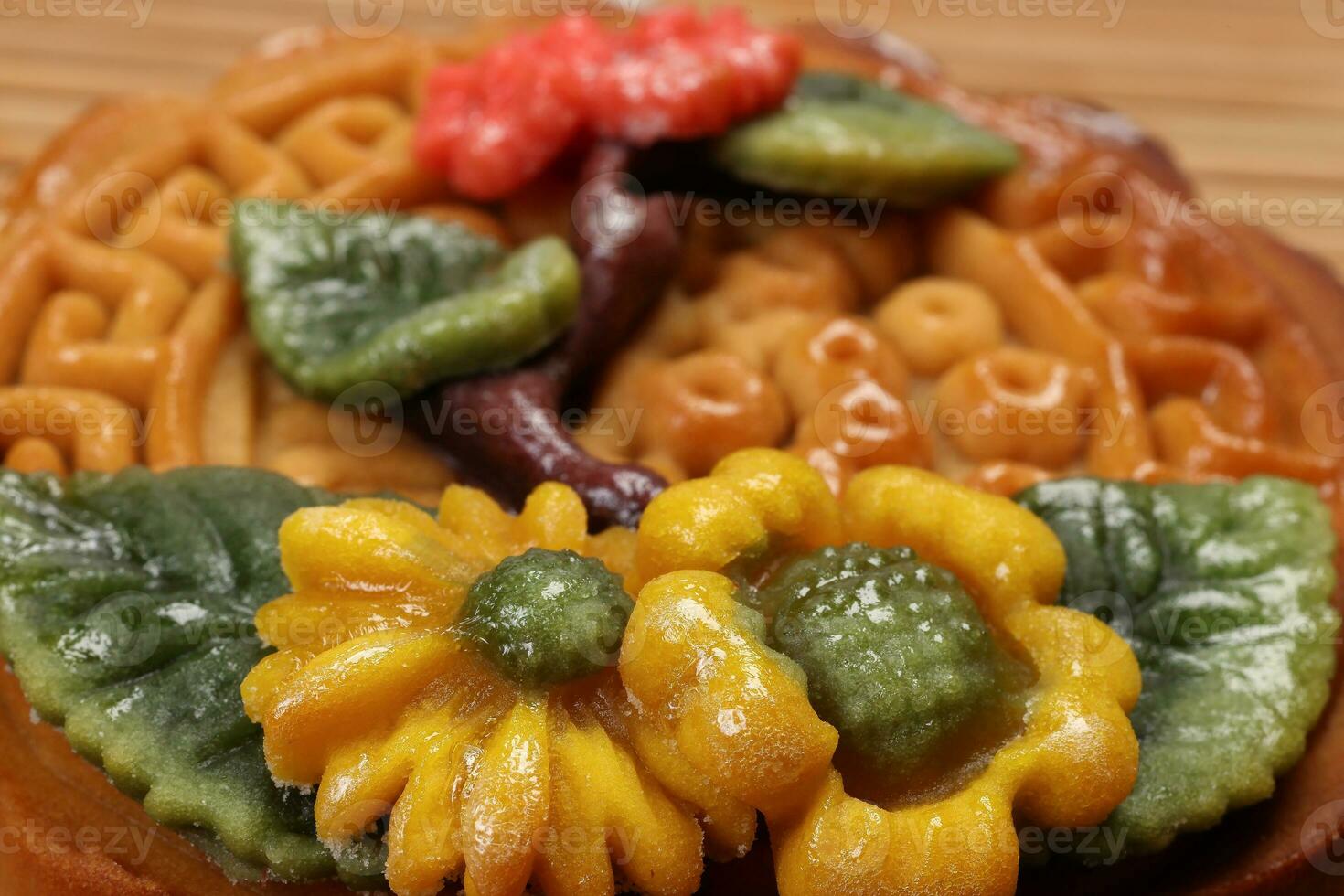 Colorful flower decorated mooncake Chinese mid autumn festival on bamboo food mat background photo