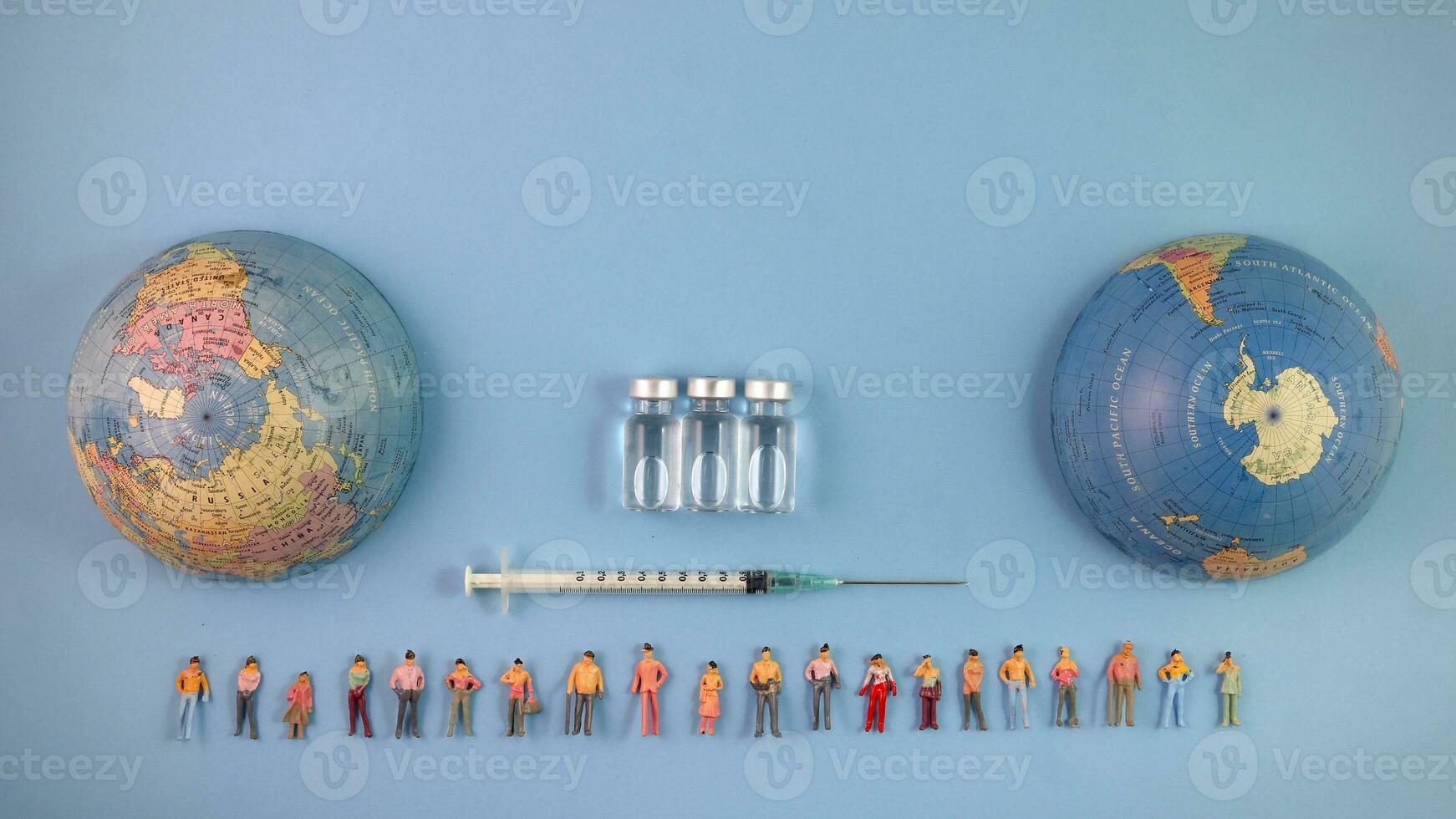 Miniature human figure figurine male female doll row line vaccine bottle medical injection syringe needle world map globe border copy text sign space on blue paper background photo