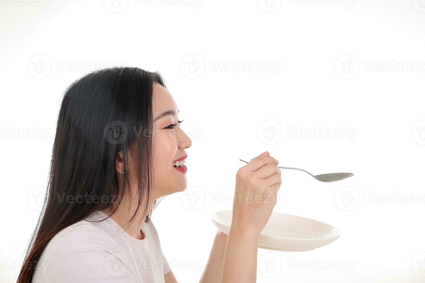 hermosa joven sur este asiático mujer fingir interino posando participación vacío cuchara en mano comer gusto alimentar oferta blanco antecedentes satisfacción sabroso foto