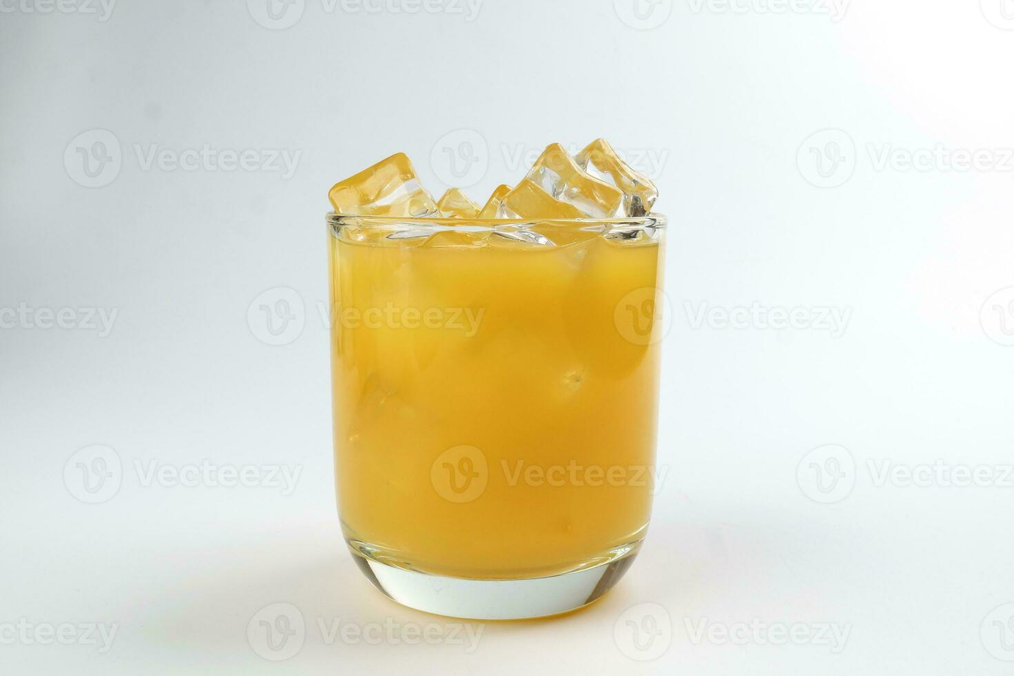 Fresco amarillo naranja jugo en vaso con hielo cubo en blanco antecedentes foto