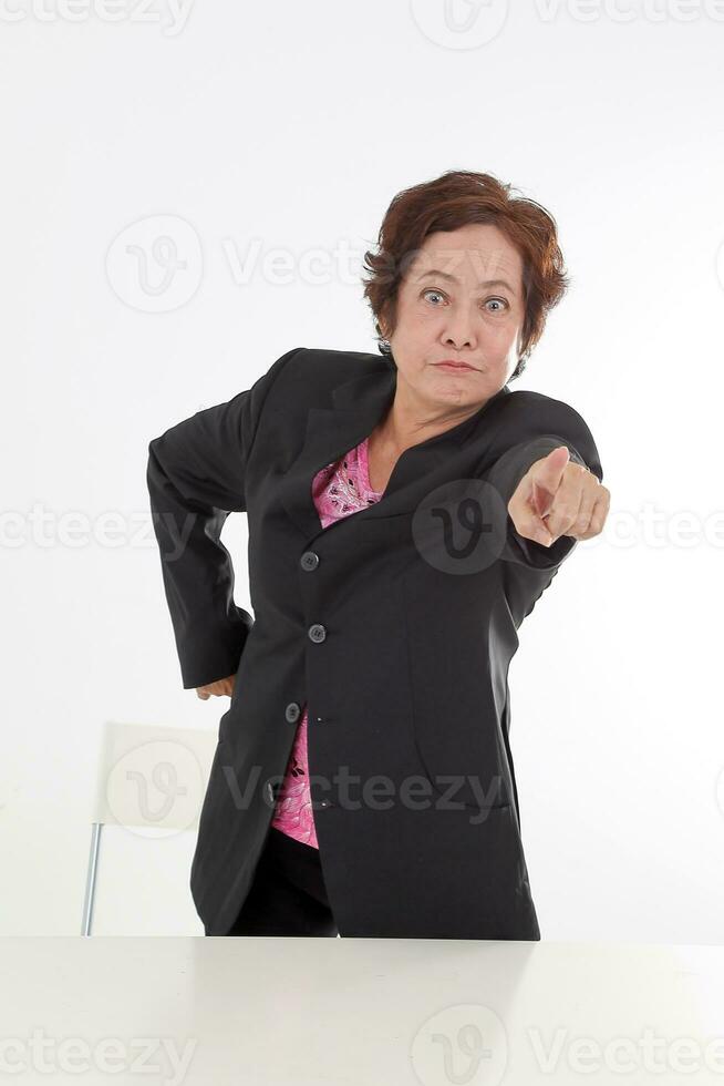 Elderly asian Chinese female on white background wearing black suit point at camera angry furious photo
