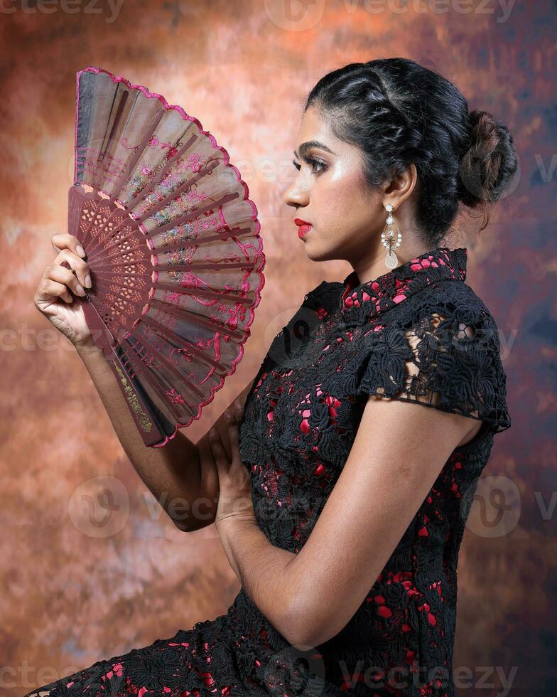 South east Asian Indian race ethnic origin woman wearing Chinese dress costume Cheongsam holding hand fan multiracial community on retro vintage background photo