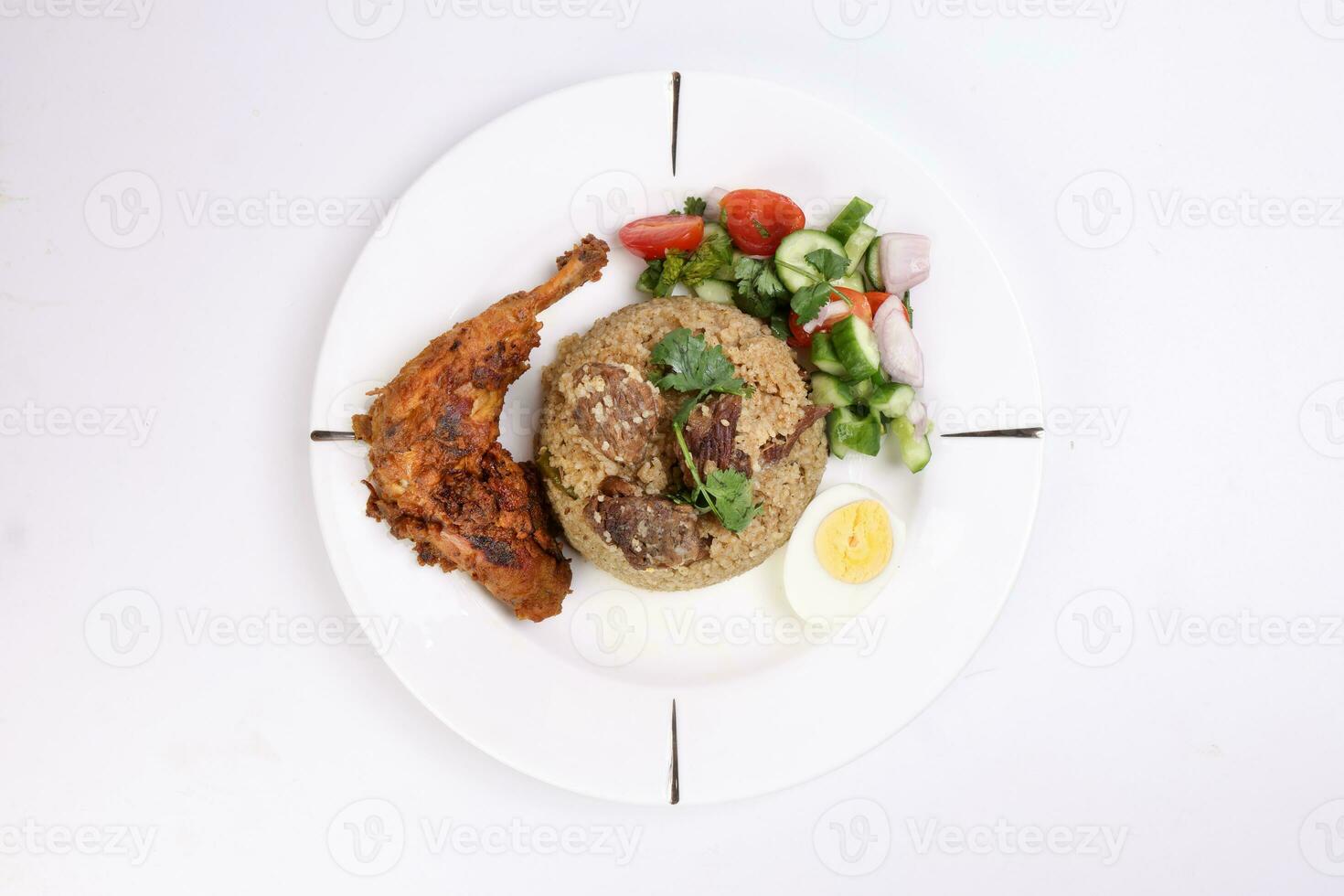 Beef Biryani Tehari with boiled egg coriander leaf garnish chicken curry pot roasted leg tomato cucumber onion chili coriander salad on white plate set over white background photo