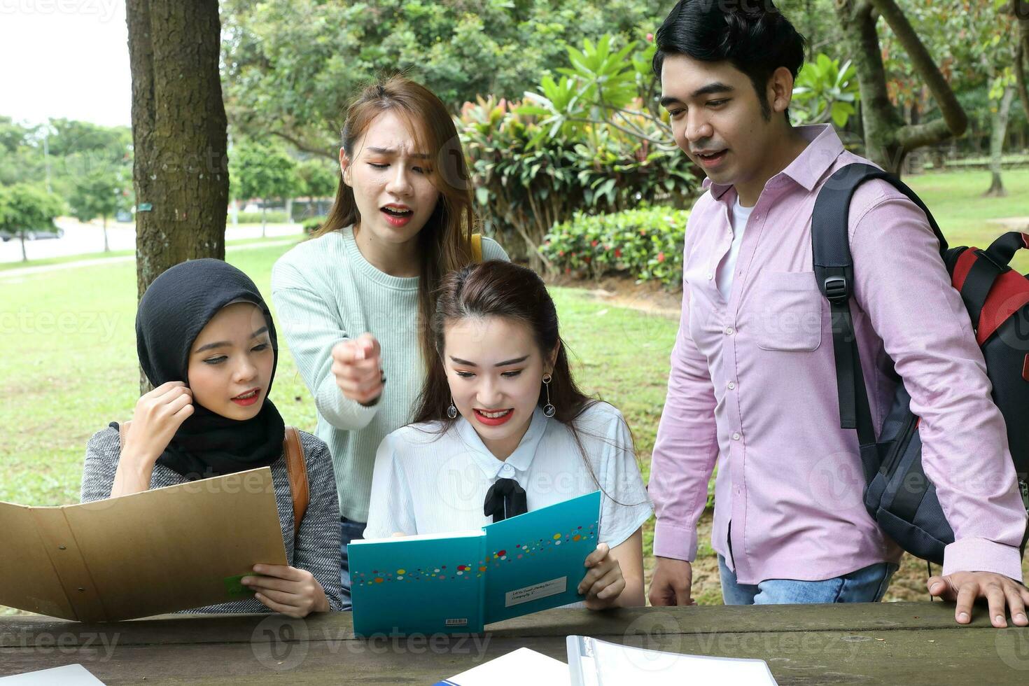 Young asian malay chinese man woman outdoor park  book file folder laptop computer phone sit stand study mingle photo
