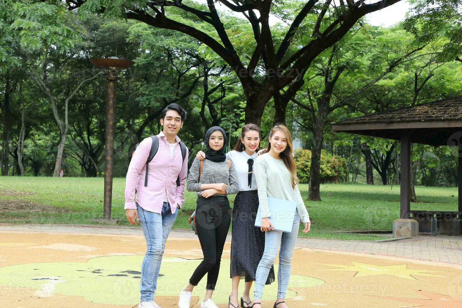 Young asian malay chinese man woman outdoor park walk stand study talk discuss point laptop file book backpack mingle fun happy photo