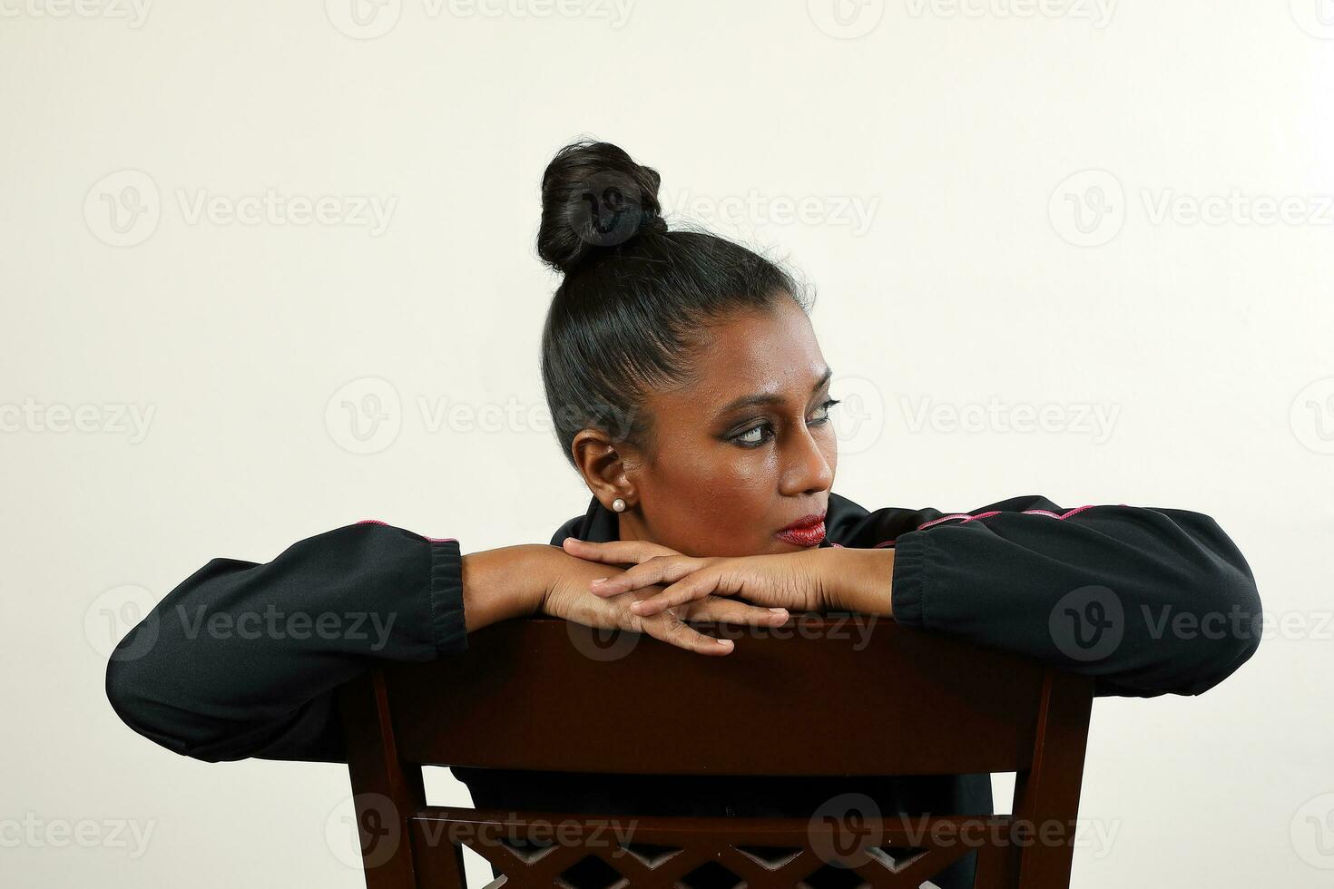 Asian Indian woman wearing black track suit sit on reverse chair pose hip hop style modern funky photo