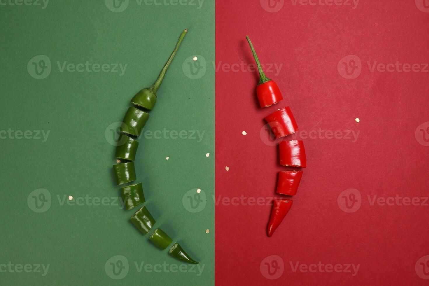 green red chilli pepper on green red paper background cut pieces seeds photo