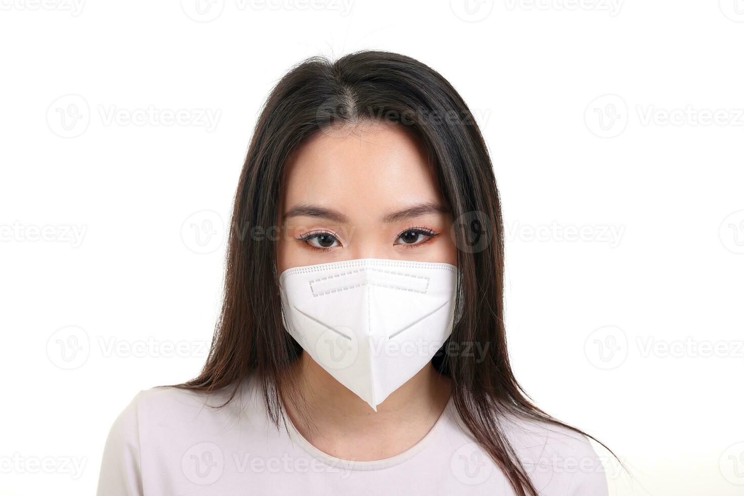 Beautiful young south east Asian woman wearing N95 anti virus bacterial surgical face mask on white background look forward photo