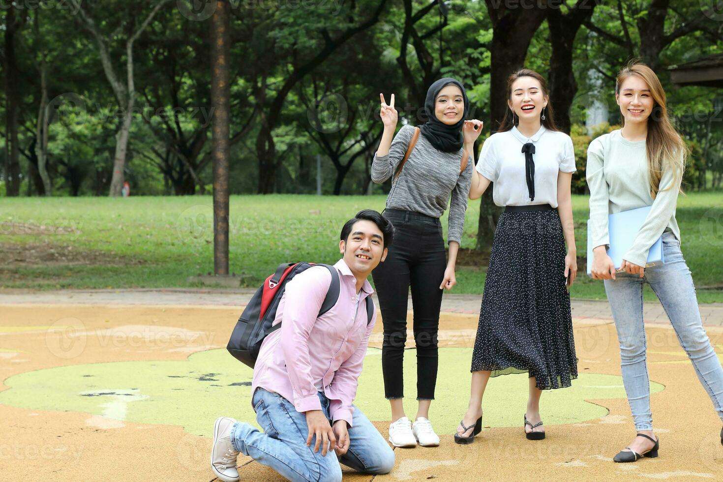 Young asian malay chinese man woman outdoor park walk stand study talk discuss point laptop file book backpack mingle fun happy photo