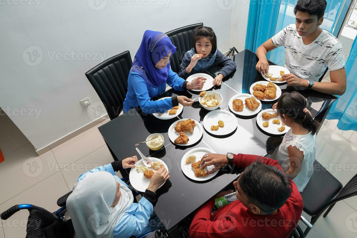 Group of southeast Asian adult child girl male female eating lunch at dining table fired chicken. They are autistic down syndrome adhd paralyzed wheelchair photo