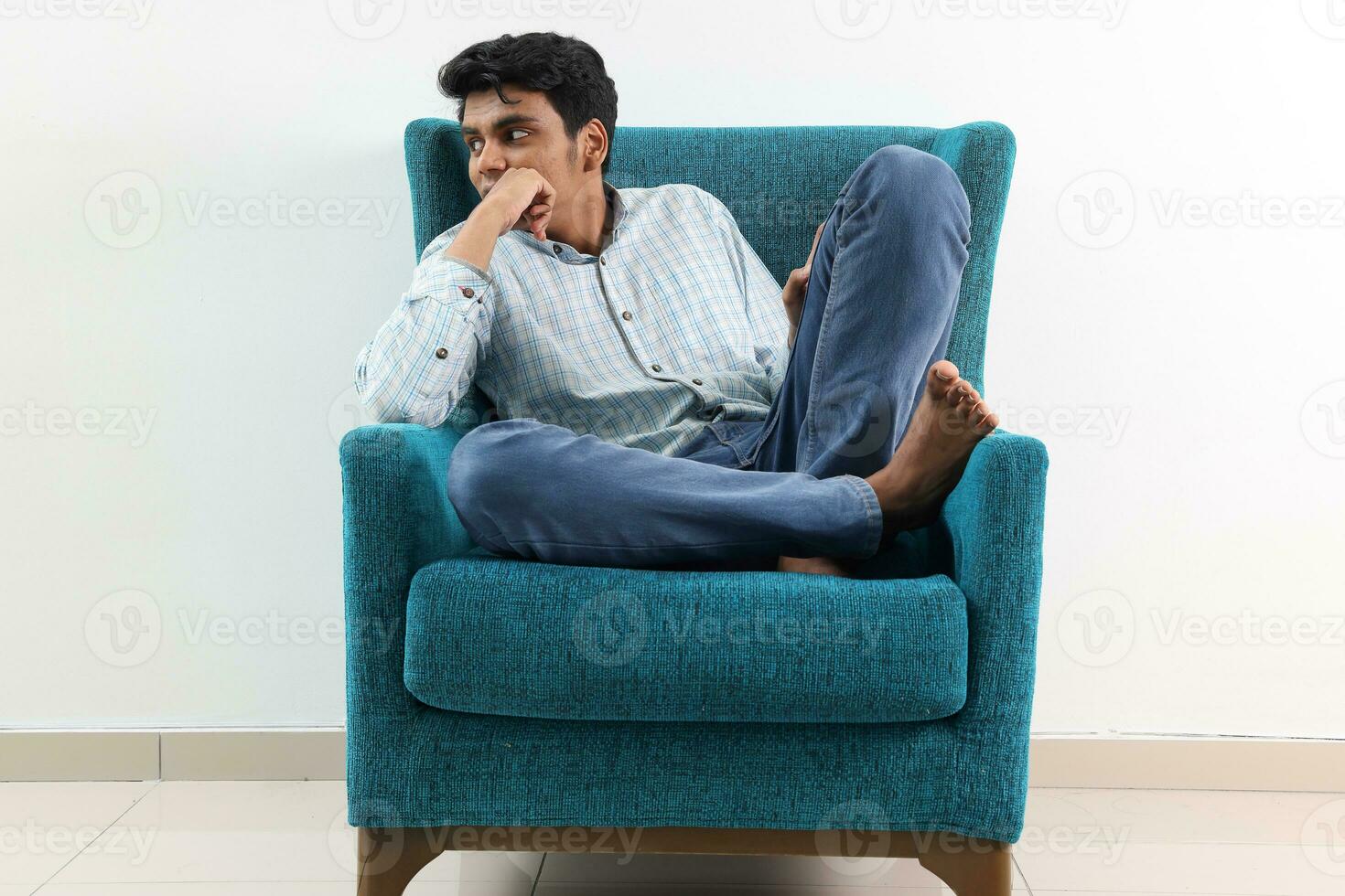 A young south east Asian sit pose look think work study emotion feelings on a blue single sofa. He is adhd and autistic photo