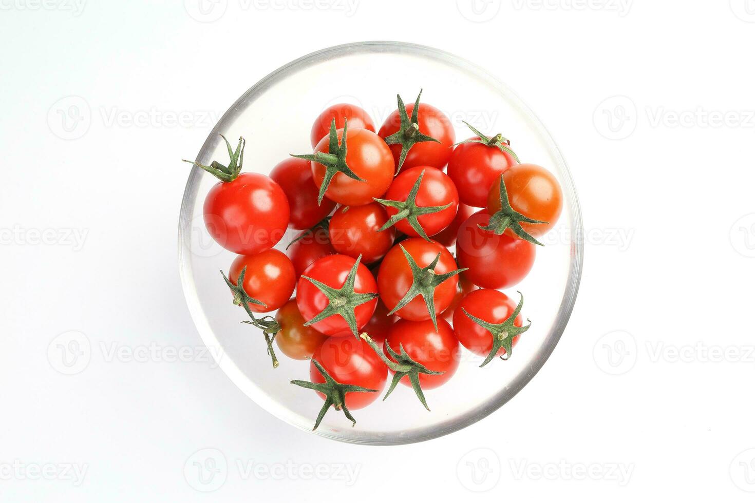 Red ripe cherry tomato with stem glass bowl on white background top view photo