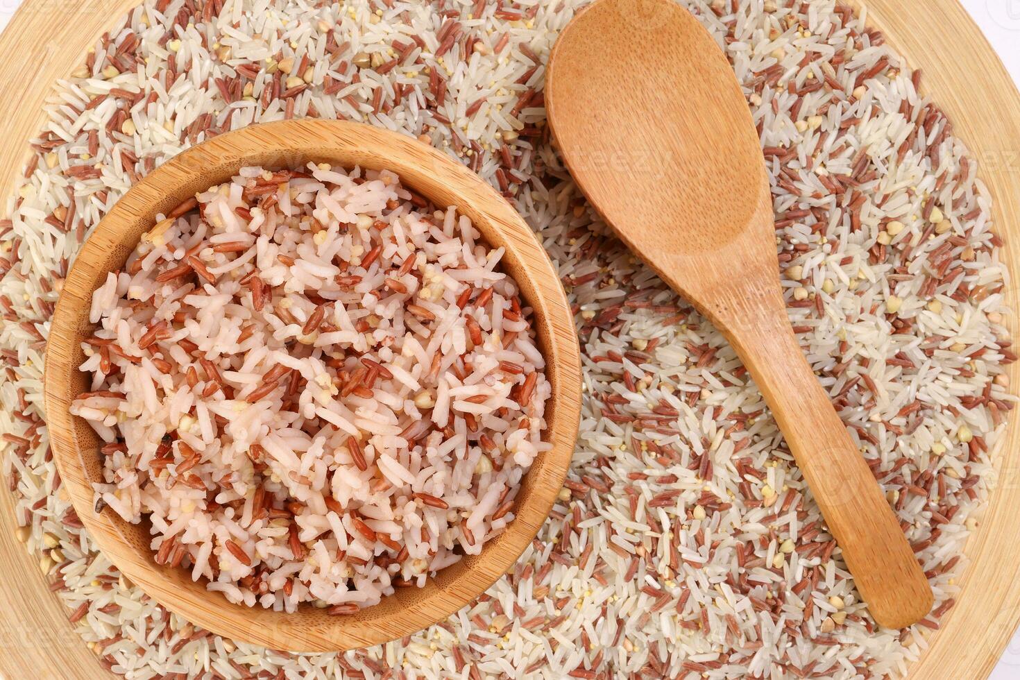 cocido y crudo mezclado bajo glucémico índice sano arroz grano basmati mijo alforfón rojo arroz en de madera cuenco terminado de madera plato cuchara en blanco antecedentes foto