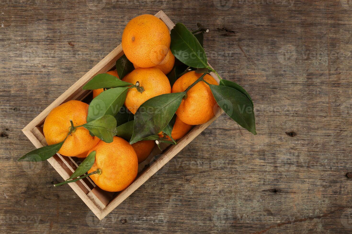 mandarin orange green leaf wood crate box on rustic wooden background photo