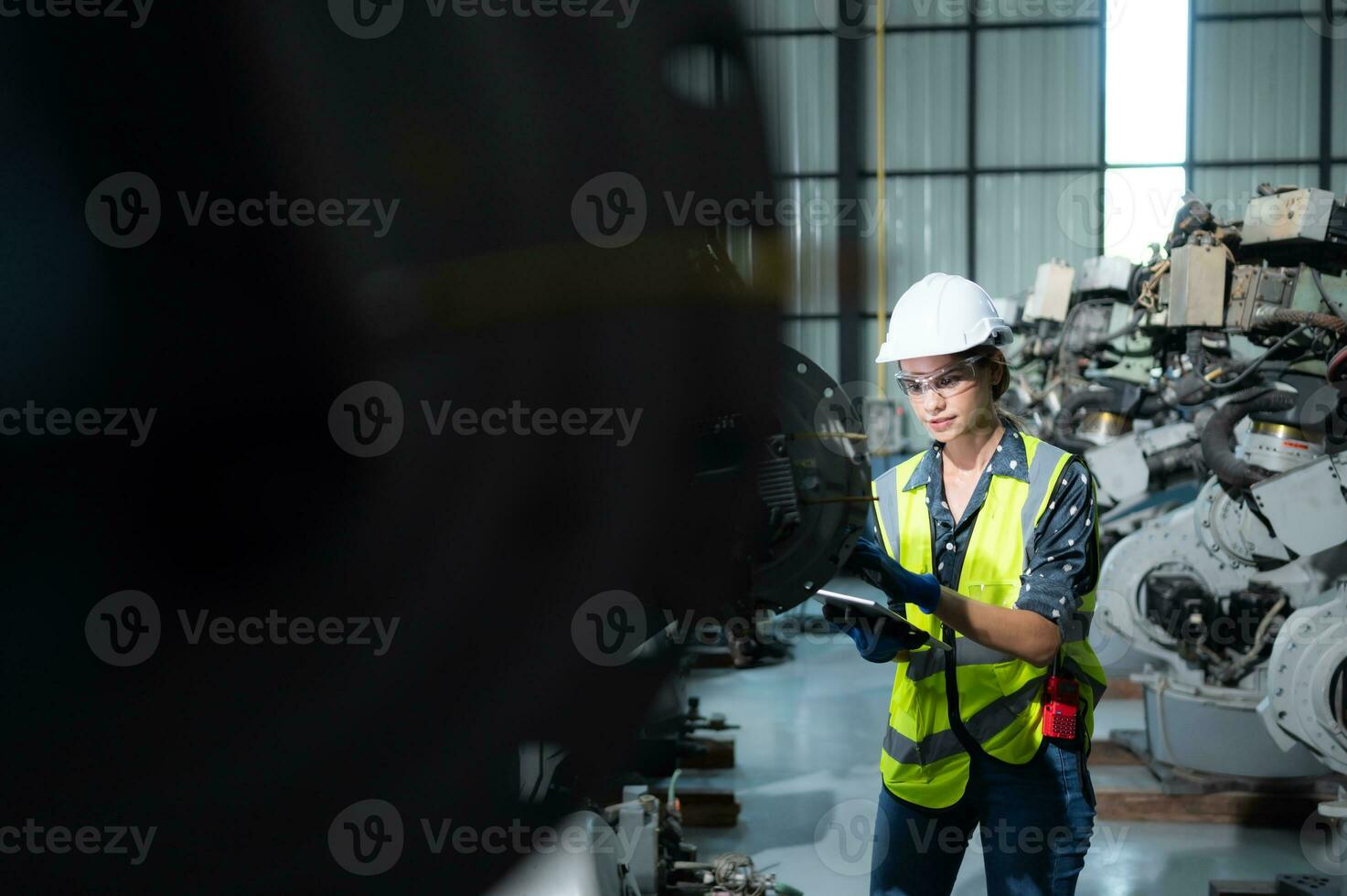 A female engineer installs a program on a robotics arm in a robot warehouse. And test the operation before sending the machine to the customer. photo