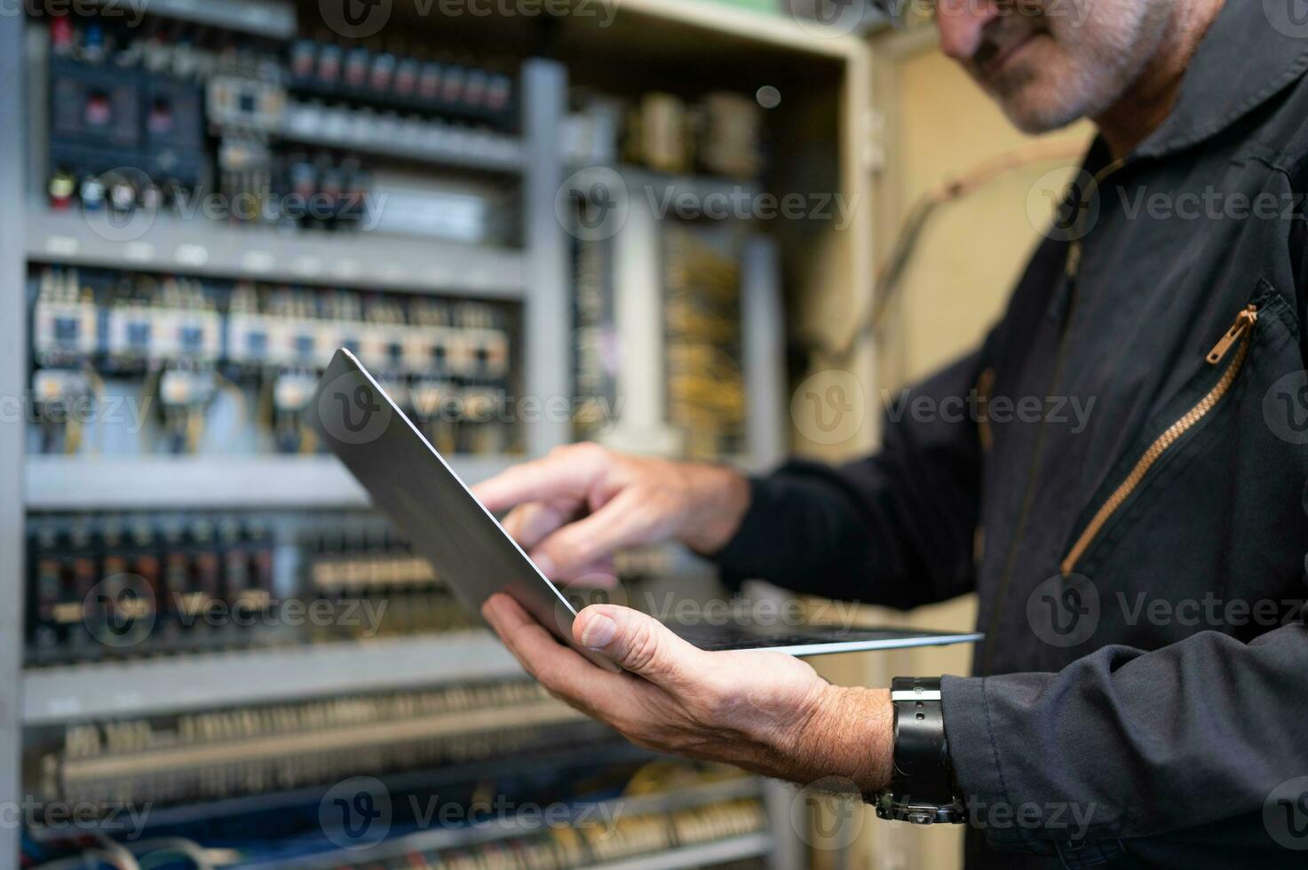 Senior engineer inspects the electrical system and repairs the mechanical system in the machine control cabinet. in order for the machine to return to normal operation photo