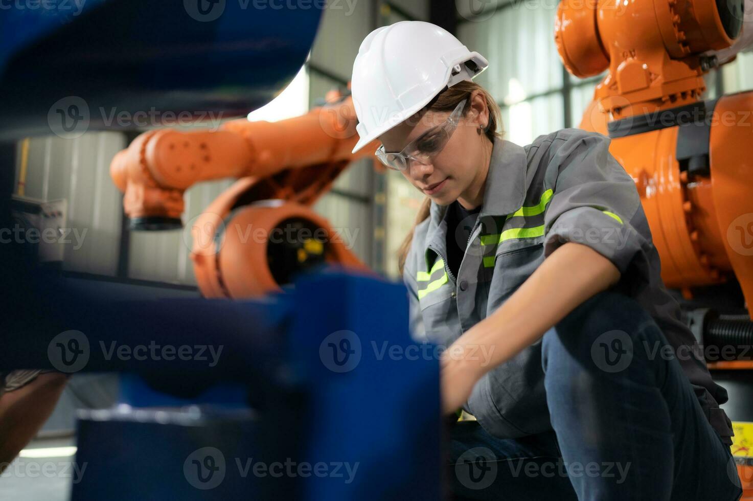 In the robots warehouse, A female engineer inspects the electrical system of every robotics arm, before delivering to the customer. photo