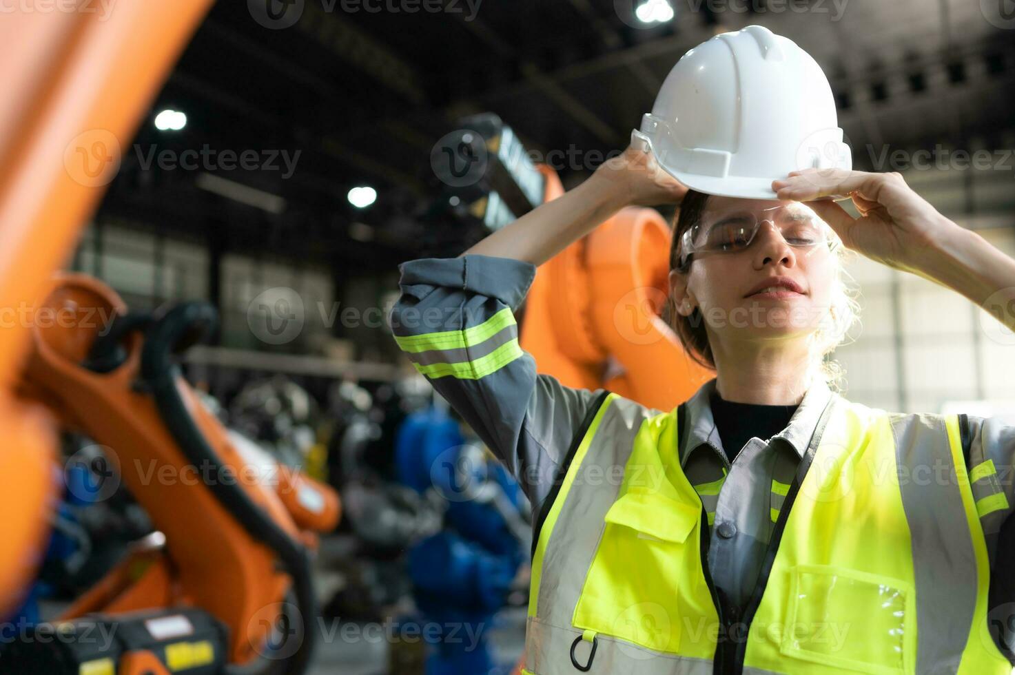 retrato de hembra ingeniero con el misión de revisión de cuentas, pruebas, mejorando software y calibrando robótica brazo. foto