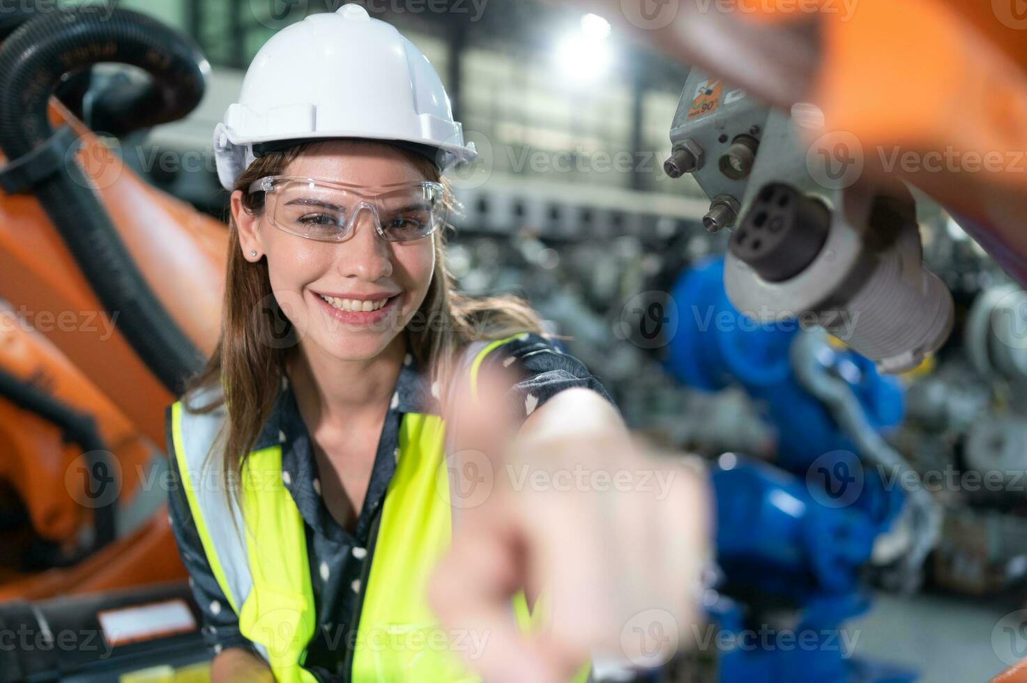 en el robots depósito, hembra ingeniero felizmente con actualización software y calibrando un robótica brazo. foto