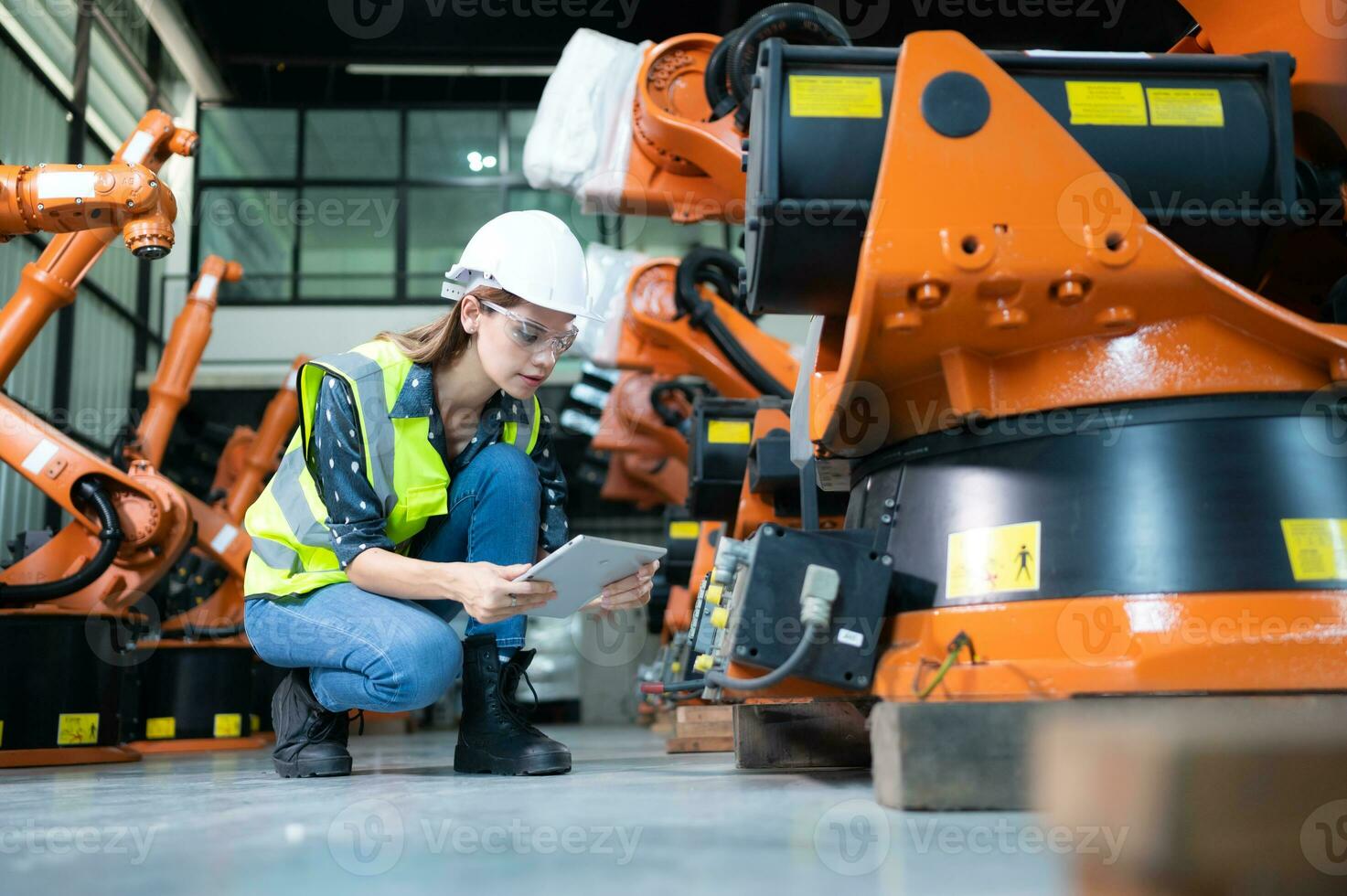 hembra técnico inspeccionando y reparando robótica brazo en robots hangar y prueba el operación de el máquina después siendo usado para un mientras, como bien como actualización el software y calibración foto