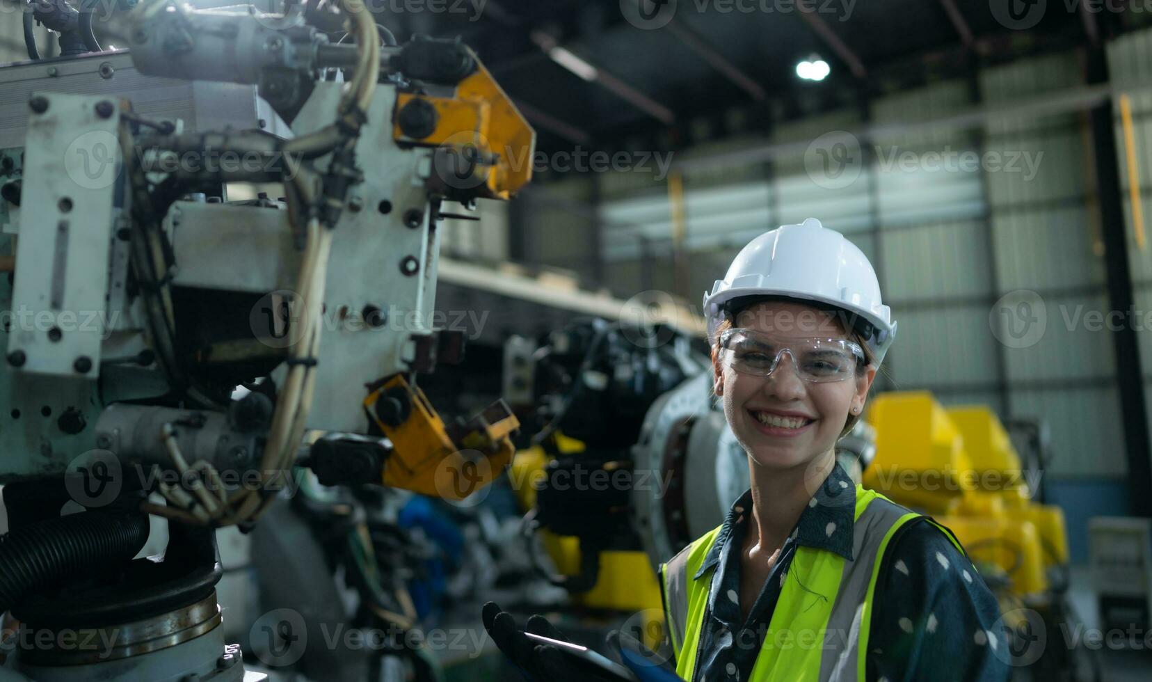 A female engineer installs a program on a robotics arm in a robot warehouse. And test the operation before sending the machine to the customer. photo