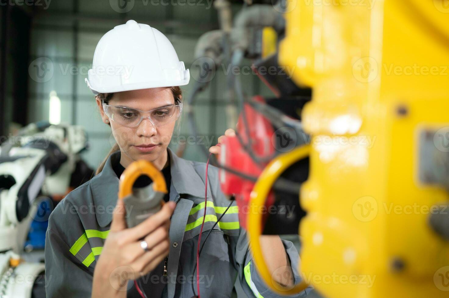 In the robots warehouse, A female engineer inspects the electrical system of every robotics arm, before delivering to the customer. photo